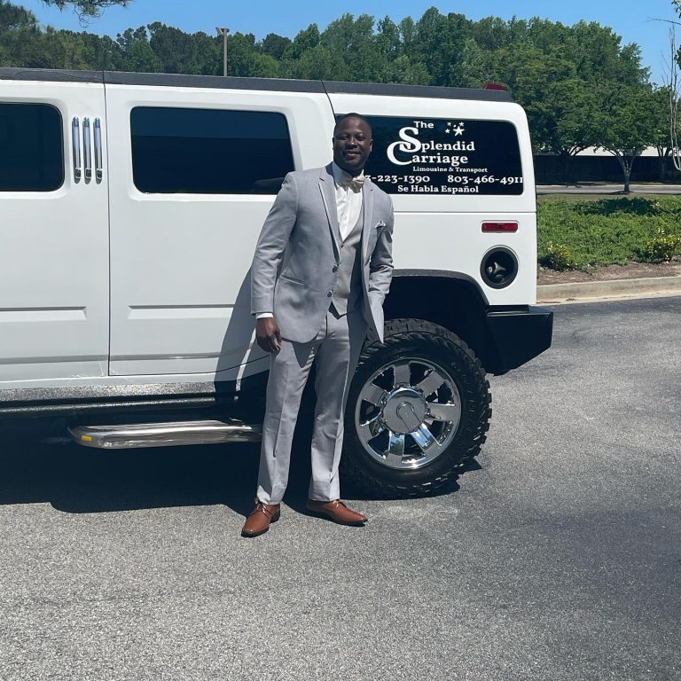 man posing in front of white limo