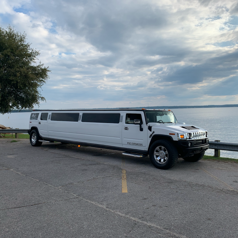 white hummer limo in front of lake